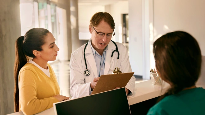 Doctor consulting with a patient at reception desk