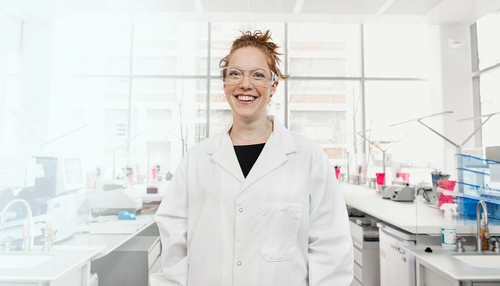 Smiling scientist in a lab wearing security glasses
