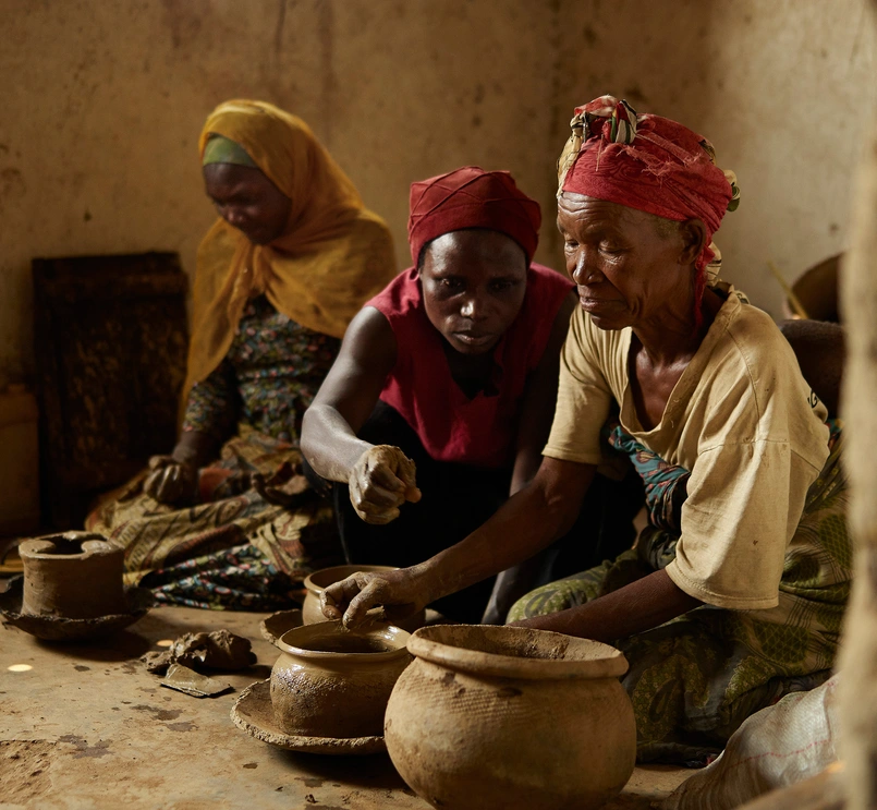 Three women making ceramic pots in Rwanda