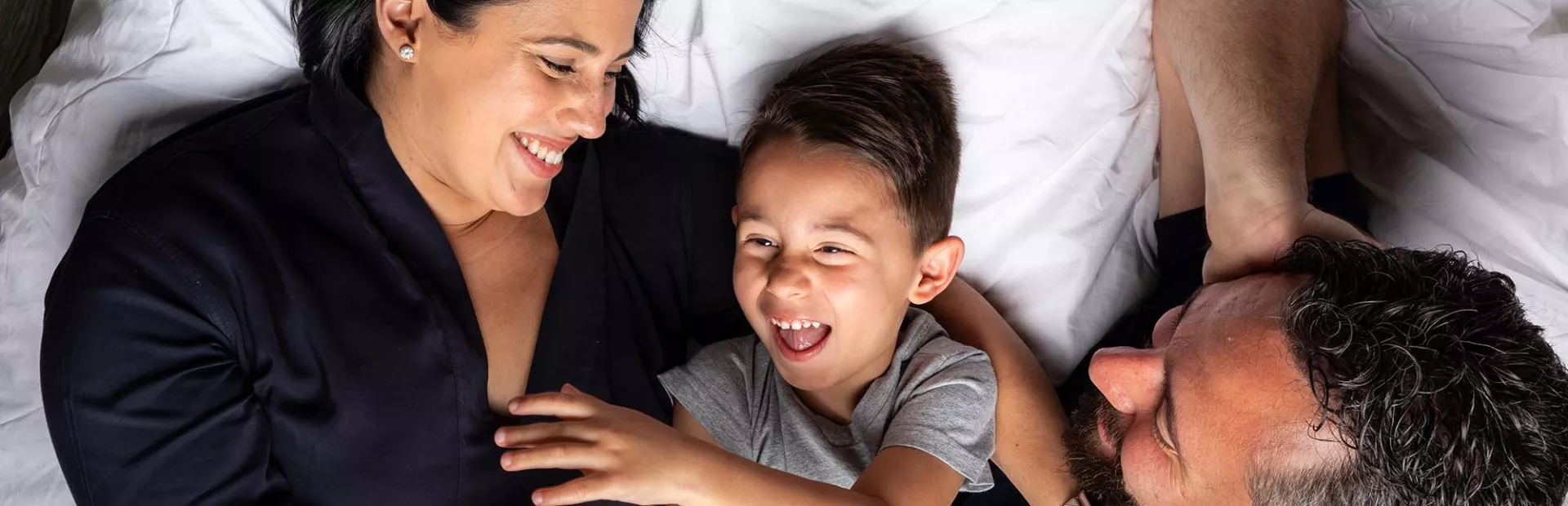 Parents snuggling with their son