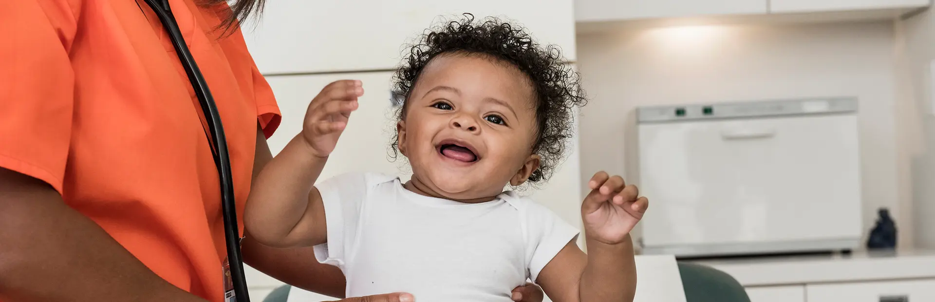 Infant patient being held by a healthcare professional during examination 