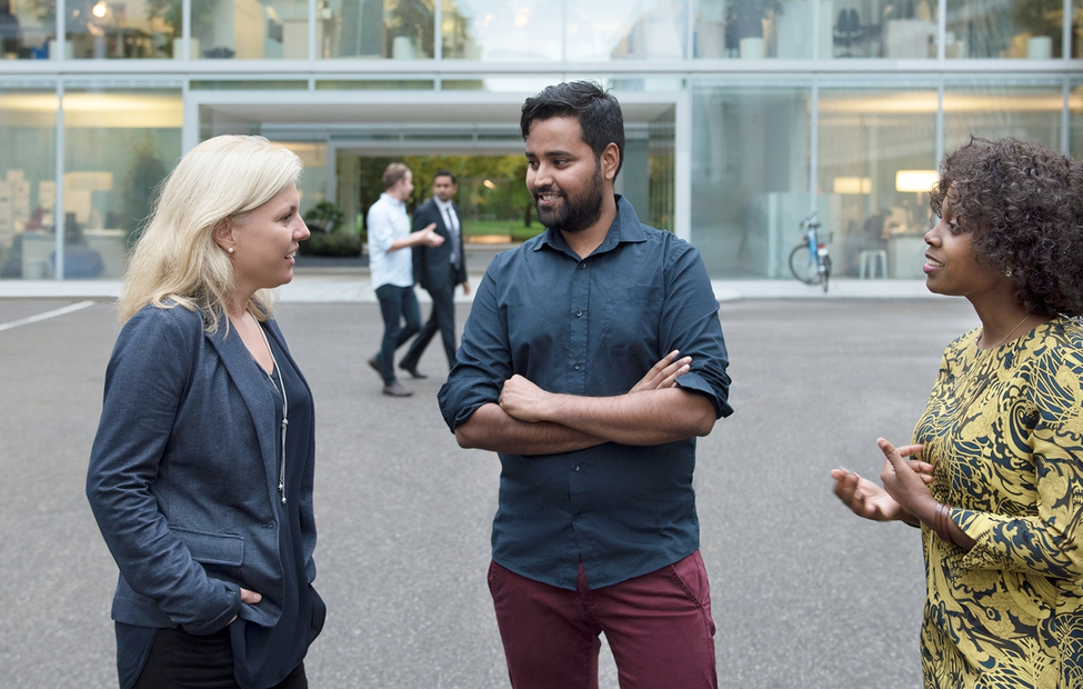 A group of Novartis associates engaged in conversation in front of the Novartis offices at Fabrikstrasse, Basel, Switzerland