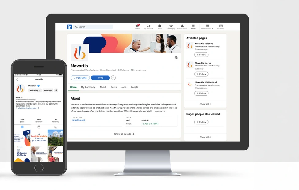 View of a desk with a phone and a monitor on it containing Novartis social media accounts