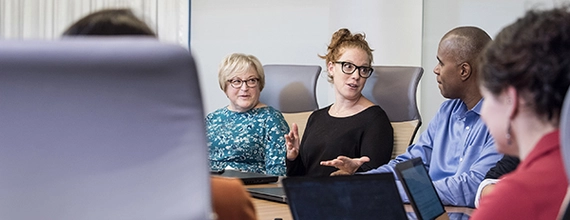 A group of Novartis associates holding a meeting in a board room