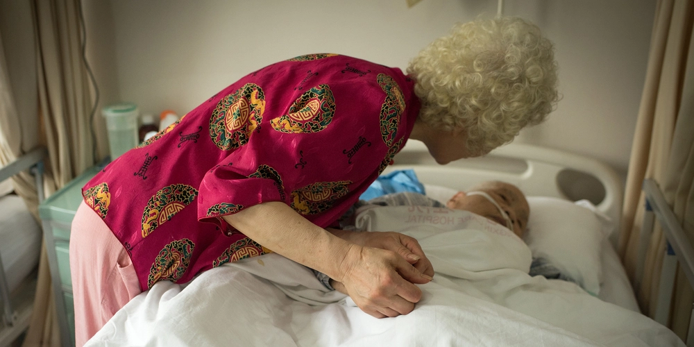 Patient in his bed visited by his wife