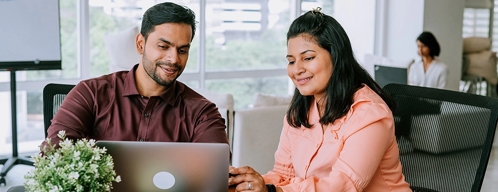 Two people looking at a laptop
