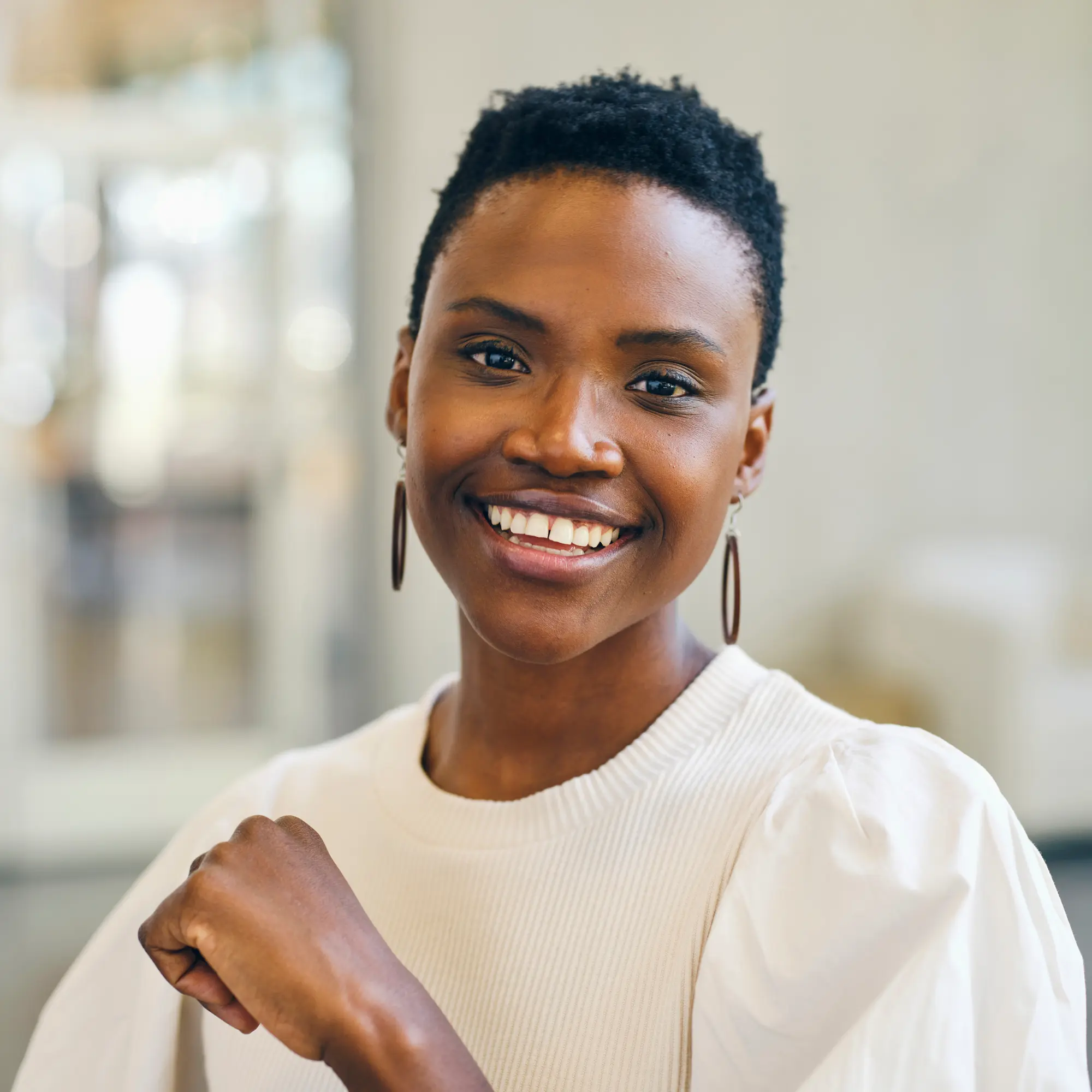 Person in a white top sitting indoors in an office