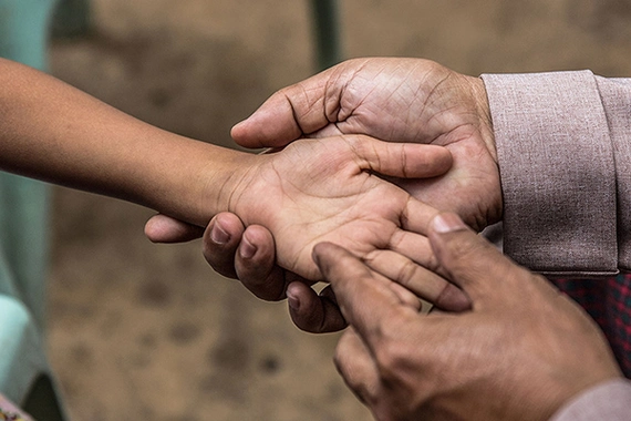 Screening child for leprosy in Asia