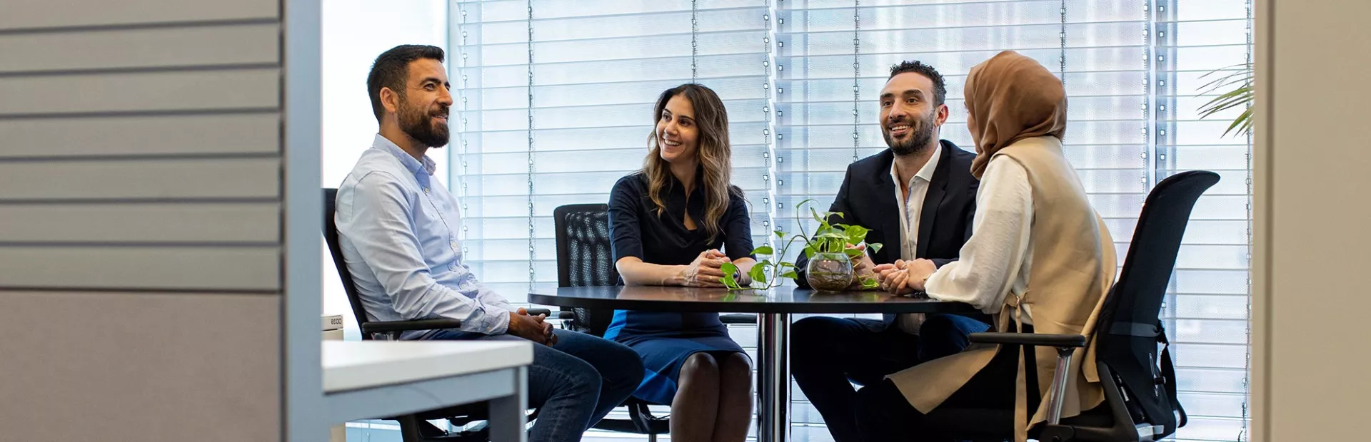 Four colleagues sitting around a table at the office