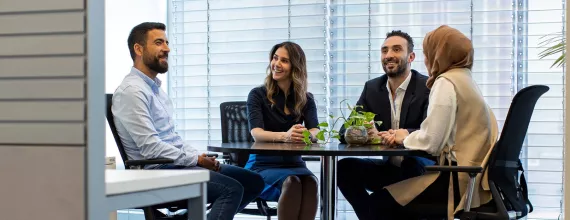 Four colleagues sitting around a table at the office