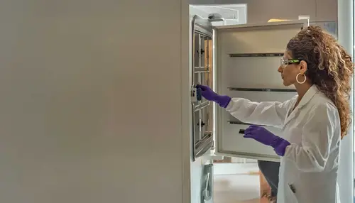 technician opening fridge in protective wear