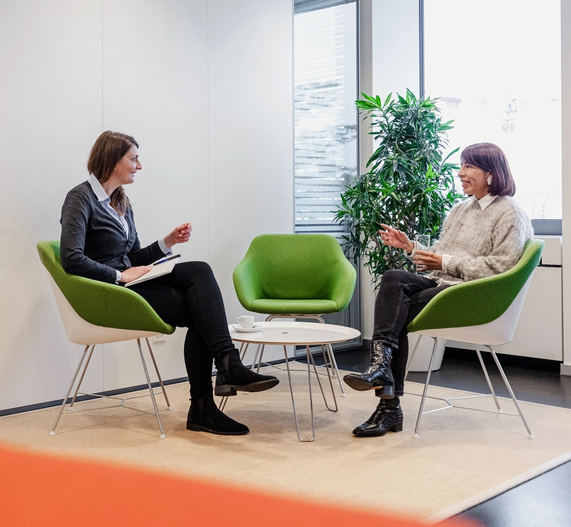 Two people chatting around table