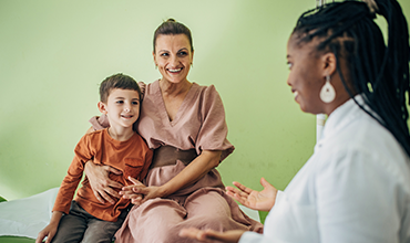 A mother and child meeting with a healthcare professional