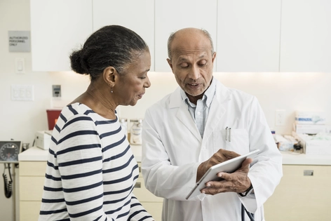 Doctor and patient reviewing medical information together in a clinical setting 