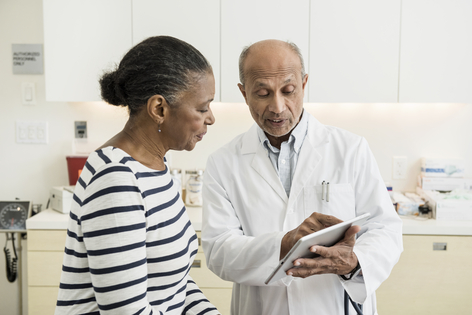 Doctor and patient reviewing medical information together in a clinical setting 