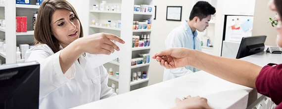 Pharmacist reading customer's prescription