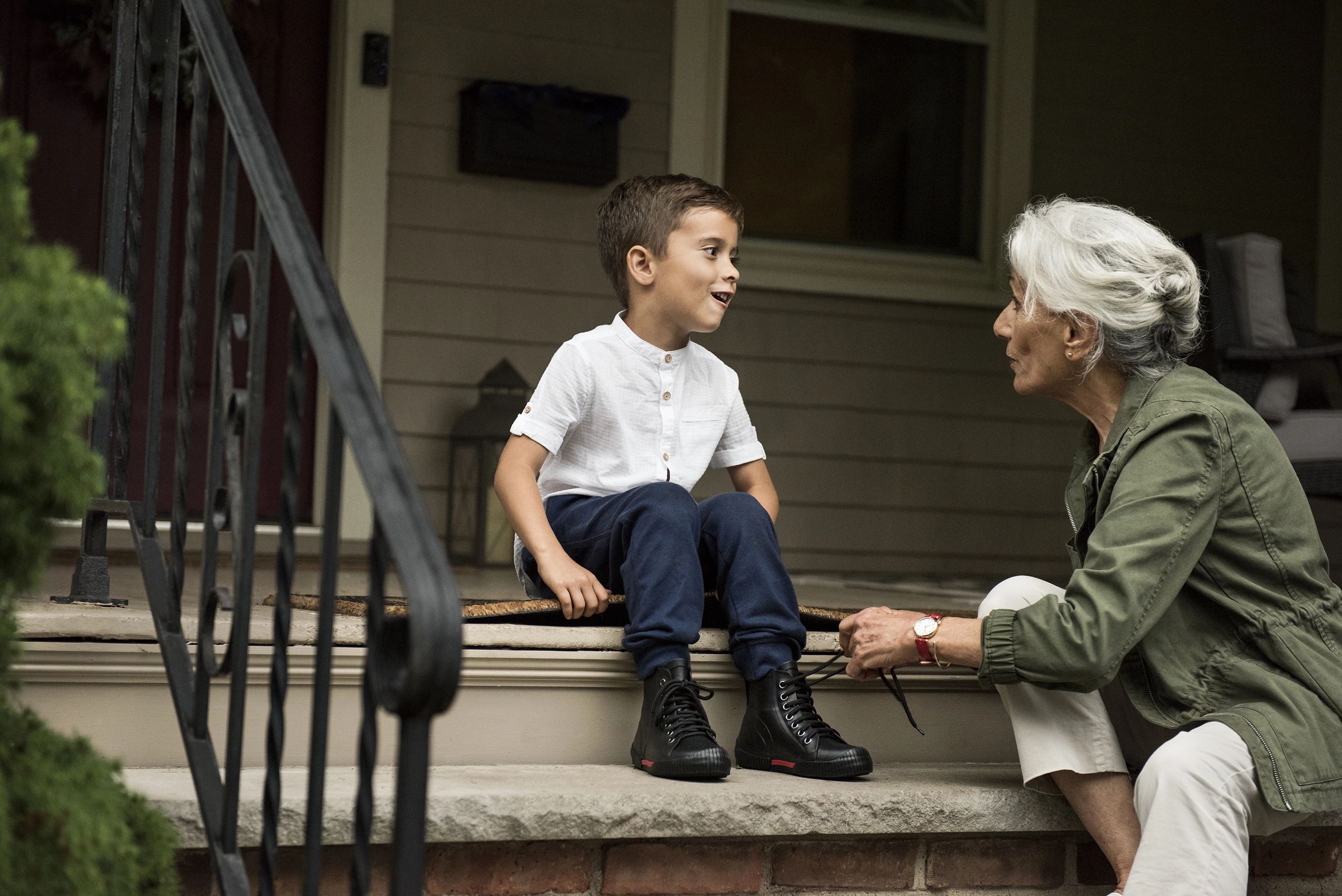 A grandmother with her grandson on steps.