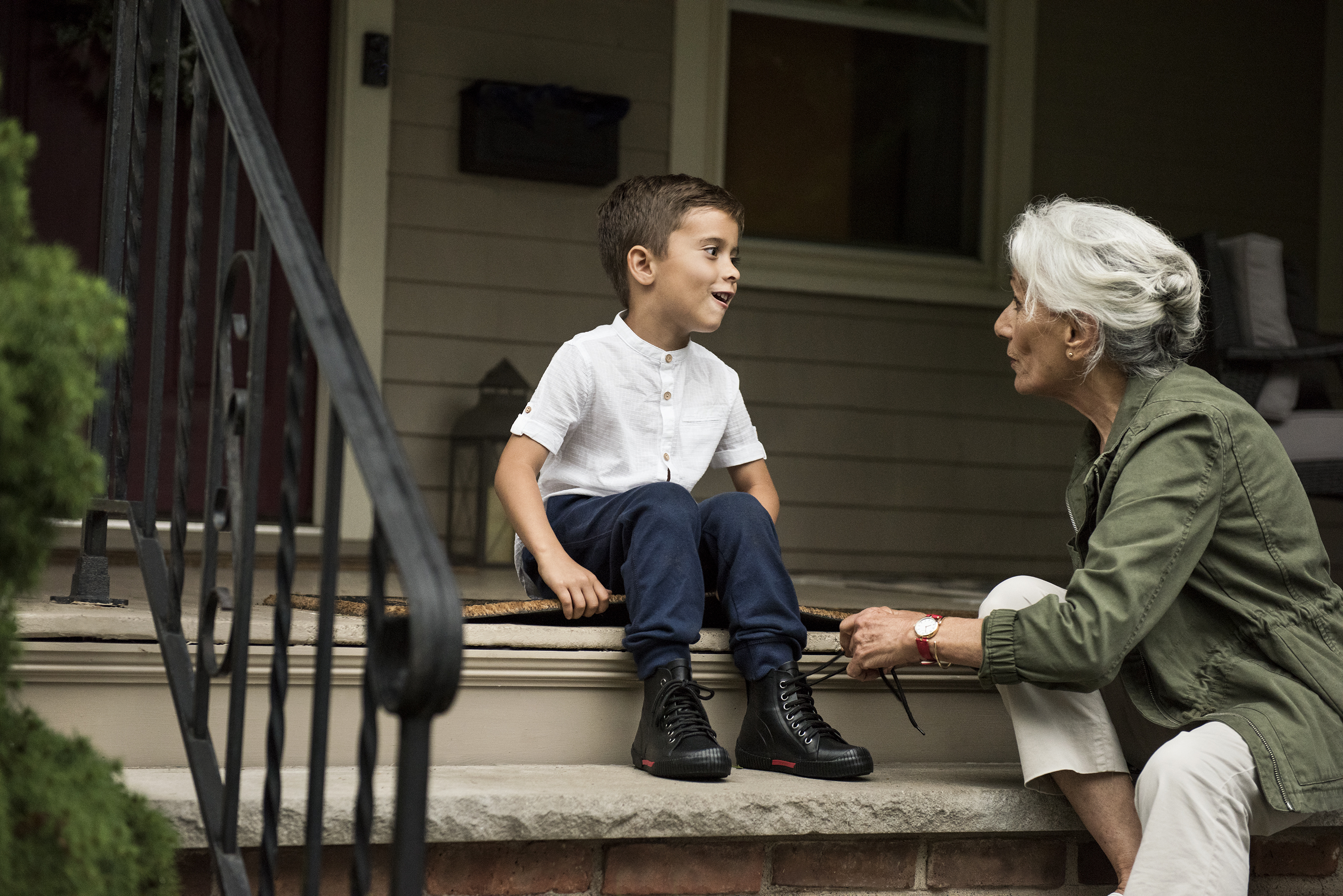 A grandmother with her grandson on steps.