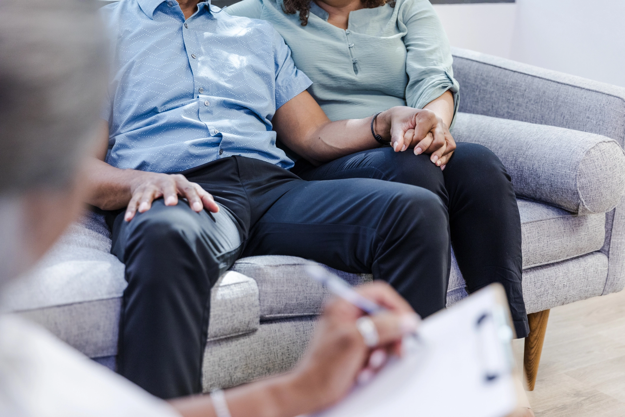 Unrecognizable Couple Holds Hands at Appointment