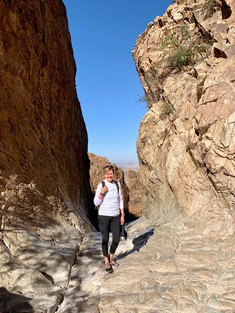 Susan shown hiking alone surrounded by large rocks