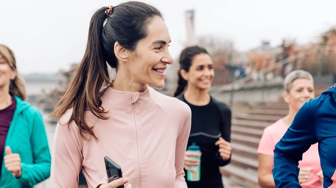 Group of Women Jogging by the River on a Cold Day