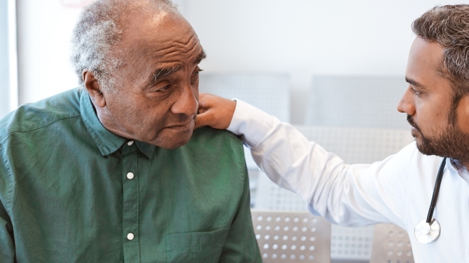 Doctor consoling male patient